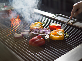 Image showing chef cooking steak with vegetables on a barbecue