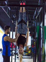 Image showing woman working out with personal trainer on gymnastic rings