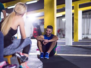 Image showing young athletes sitting on the floor and relaxing