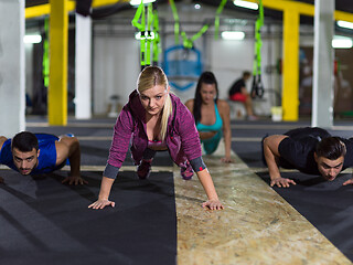 Image showing young healthy people doing pushups