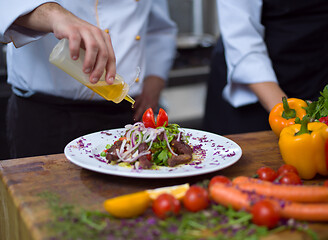 Image showing Chef finishing steak meat plate