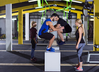 Image showing athletes working out  jumping on fit box