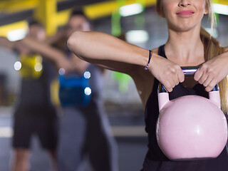 Image showing athletes doing exercises with kettlebells