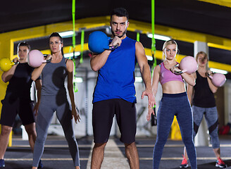 Image showing athletes doing exercises with kettlebells