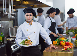 Image showing Chef holding dish of fried Salmon fish fillet