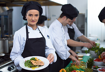 Image showing Chef holding dish of fried Salmon fish fillet