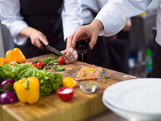 Image showing Chef hands preparing marinated Salmon fish