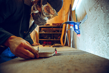 Image showing Portrait of handsome carpenter working with skate at workshop