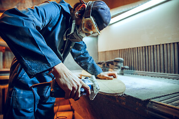 Image showing Carpenter using circular saw for cutting wooden boards.