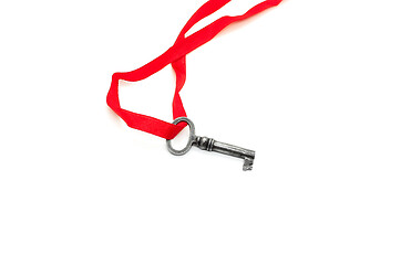 Image showing Vintage silver key with red ribbon on white background