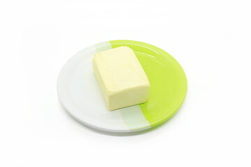 Image showing Piece of butter on a two-color plate