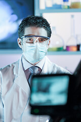 Image showing Laboratory hospital clinic doctor, scientist or exper, wearing protacive mask while addressing public in media interview explaining preventive measures against corona virus pandemic outbreak