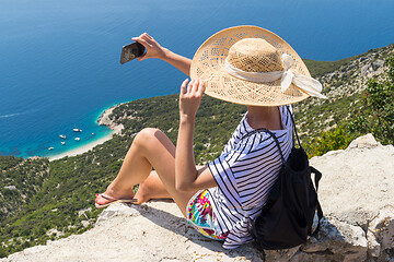 Image showing Active sporty woman on summer vacations taking selfie picture while enjoying beautiful coastal view of Cres island, Croatia from Lubenice traditional costal village