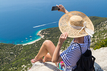 Image showing Active sporty woman on summer vacations taking selfie picture while enjoying beautiful coastal view of Cres island, Croatia from Lubenice traditional costal village