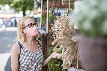 Image showing Casual woman shopping outdoor at open market stalls wearing fase masks for protection from corona virus pandemic in Munchen, Germany