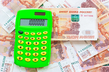 Image showing The number 1,000,000 is written on the calculator, the calculator lies on a pile of money