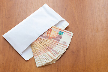 Image showing There is a bundle of money in an envelope on the table