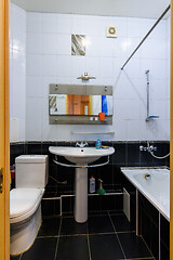 Image showing General view of a classic bathroom interior in an apartment, with black and white tiles