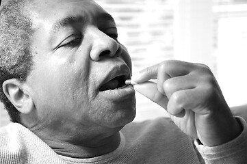 Image showing Man taking his medications.