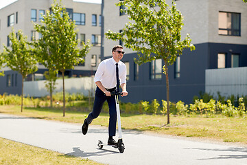 Image showing young businessman riding electric scooter outdoors