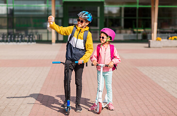 Image showing happy school kids with scooters taking selfie