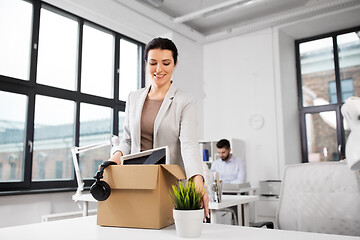 Image showing happy businesswoman with personal stuff at office