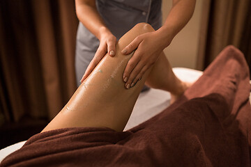 Image showing woman lying and having leg massage with gel at spa