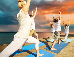 Image showing group of people making yoga exercises outdoors