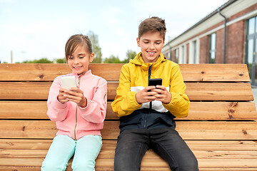 Image showing children with smartphones sitting on street bench