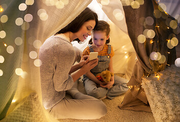 Image showing happy family with smartphone in kids tent at home