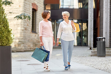 Image showing senior women with shopping bags walking in city