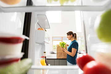 Image showing view to woman with purchased food from home fridge