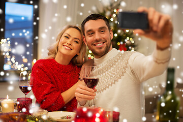 Image showing happy couple taking selfie at christmas dinner