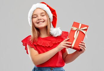 Image showing pleased girl in snata hat with christmas gift