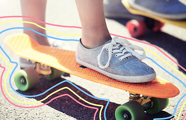 Image showing close up of female feet riding short skateboard