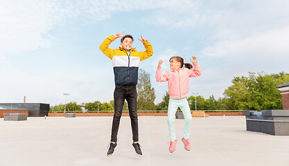 Image showing happy children jumping on roof and showing peace