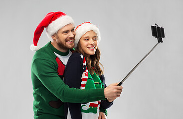 Image showing happy couple in christmas sweaters taking selfie