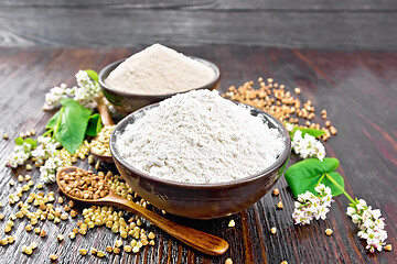 Image showing Flour buckwheat green and brown in bowls with flowers on board