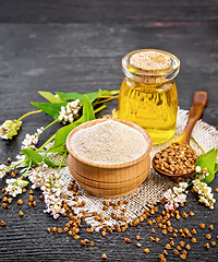 Image showing Flour buckwheat brown in bowl with oil on wooden board