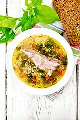 Image showing Soup with couscous and spinach in plate on board top