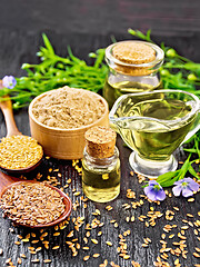 Image showing Oil flaxseed with flour and seeds on wooden board