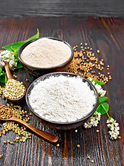 Image showing Flour buckwheat green and brown in bowls with flowers on wooden 