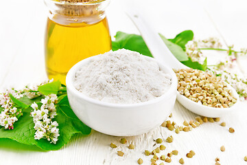 Image showing Flour buckwheat green in bowl with oil on light board