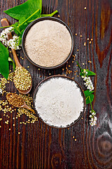 Image showing Flour buckwheat green and brown in bowls with flowers on board t