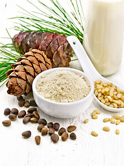 Image showing Flour cedar in bowl and nuts in spoon on white board