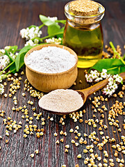 Image showing Flour buckwheat brown in spoon with oil on wooden board