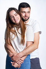 Image showing Smiling young couple hugging, studio portrait over light background