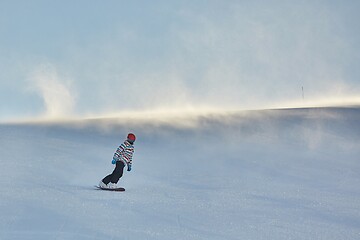 Image showing Female snowboarder in sun flare