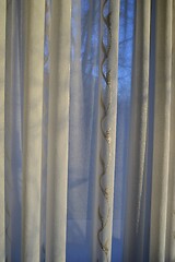 Image showing translucent curtains behind which the sky and trees