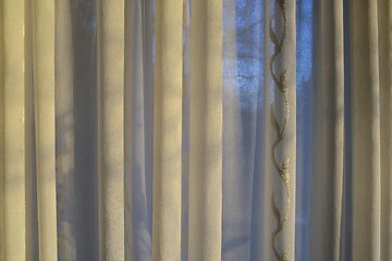 Image showing translucent curtains behind which the sky and trees